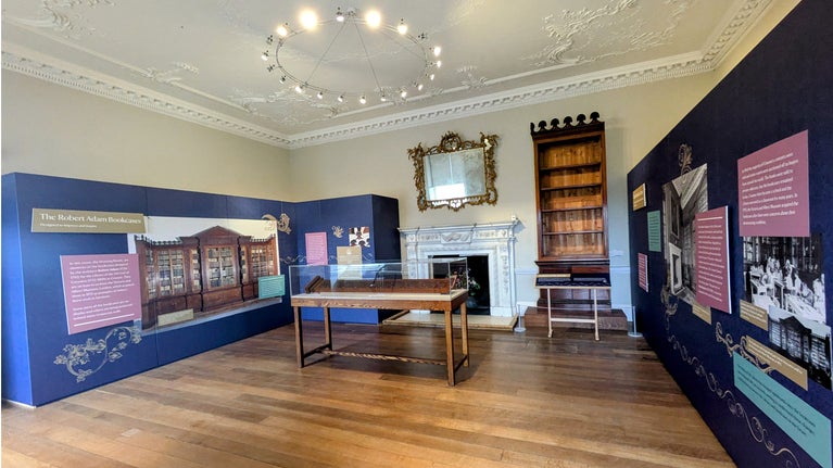 A display in the library of Crome Court, with text and photos of the historic bookcases and a section of bookcase on show.
